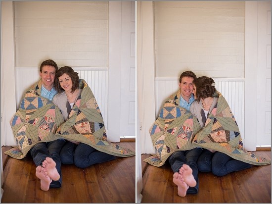 Happy couple cuddling under a quilt on a wooden floor
