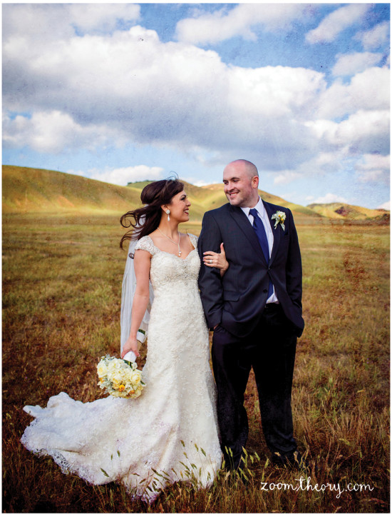 Happy couple on their wedding day, standing in a field