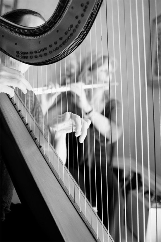 Black and white photo of a harpist playing with a flute player