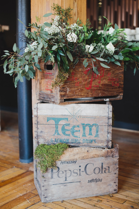Vintage crates stacked with flowers and moss decor