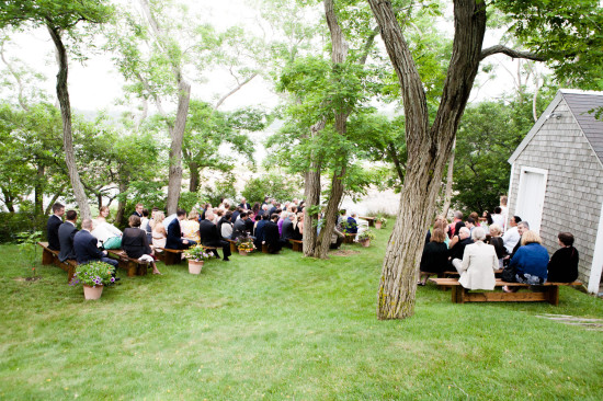 Outdoor wedding ceremony with guests seated under trees