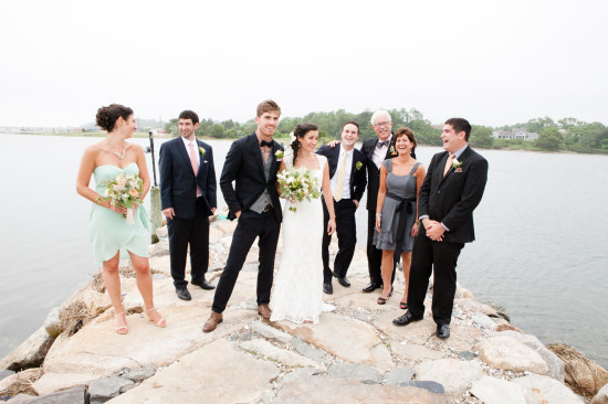 Wedding party smiling on a waterfront stone path