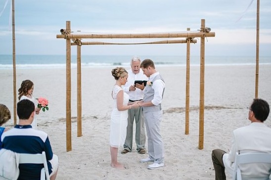 Beach wedding ceremony with bride and groom holding hands