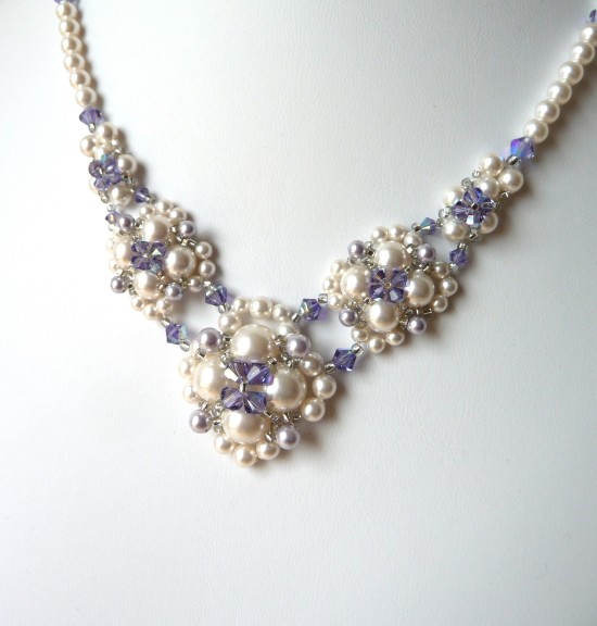 Elegant pearl and amethyst beaded necklace on white background