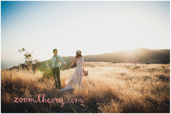 Romantic couple holding hands in a field at sunset
