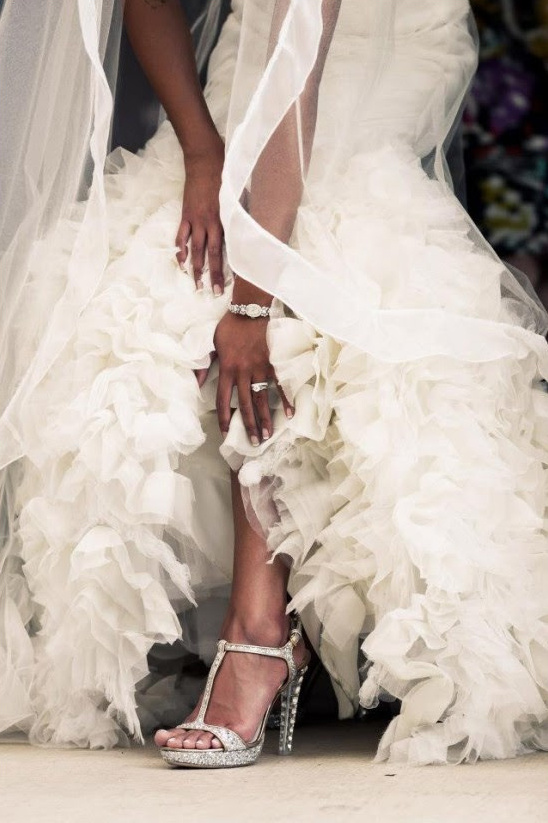 Bride in flowing gown showing off sparkly wedding heels