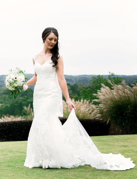 Bride in a lace wedding dress holding flowers