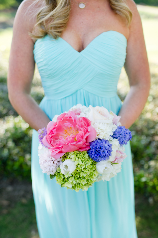 Bride holding a colorful wedding bouquet wearing a blue dress