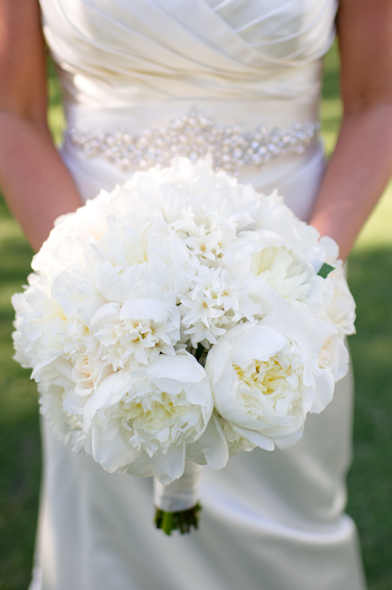 Bride holding a beautiful white peony wedding bouquet closeup