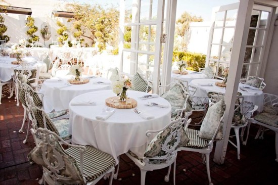 Outdoor wedding reception with white tables and chairs