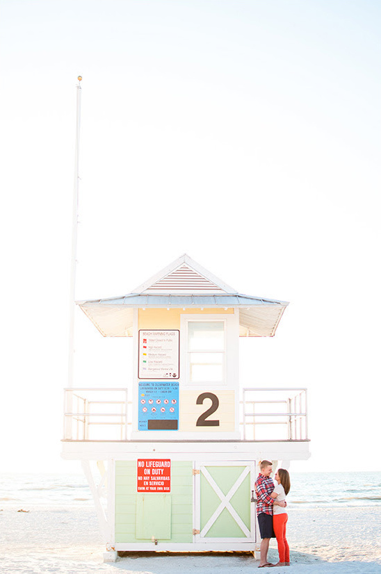 Couple embracing by a lifeguard tower on a sunny beach