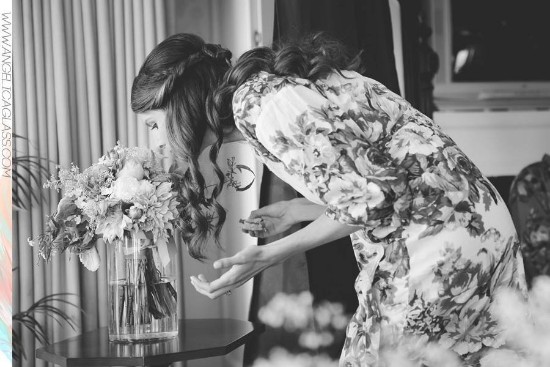Bride admires bridal bouquet of flowers in a floral robe, black and white