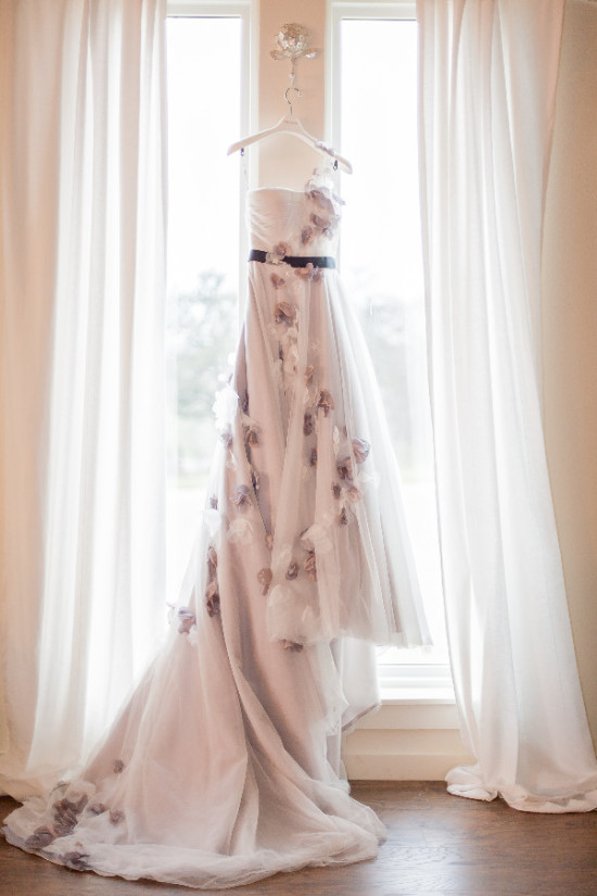 Elegant bridal gown hanging by a window, ready for the wedding