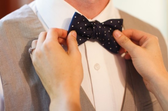 Helping to fix a stylish bow tie on a man