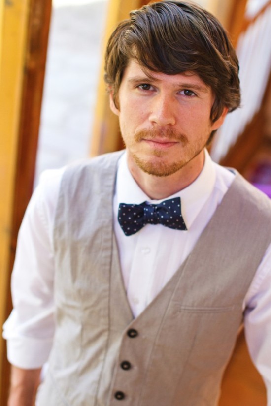 Handsome man in a vest and bow tie looking forward, close-up portrait