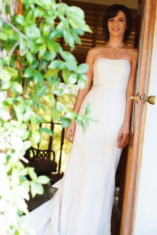 Bride in white wedding dress smiling in a doorway
