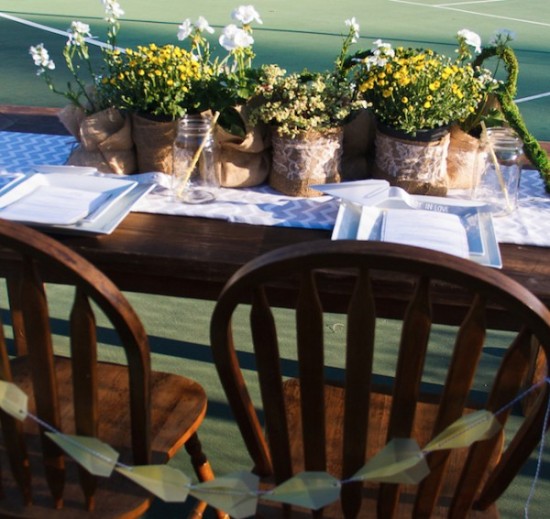 Elegant table setting with flowers, plates, and wooden chairs