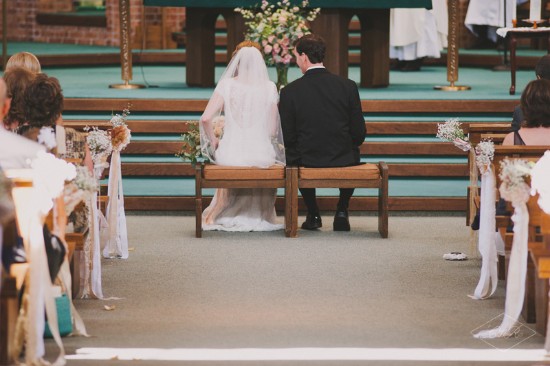 Bride and groom sit during the wedding ceremony in church