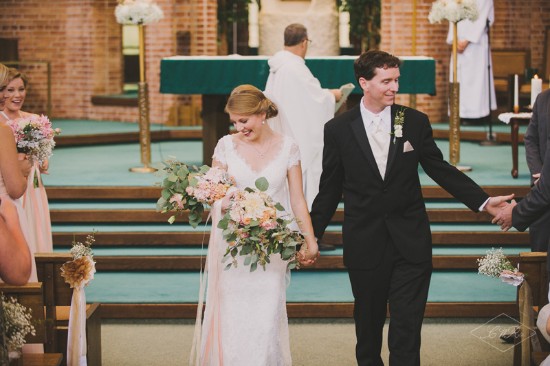 Happy bride and groom leaving church, holding hands after wedding