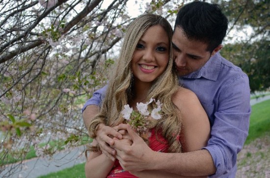 Happy couple hugging under a blossoming tree with flowers