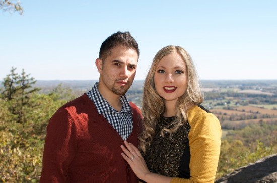A loving couple poses for a photo in a scenic outdoor setting