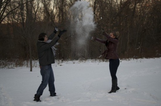 Couple throwing snow in the air during wintertime, fun and playful
