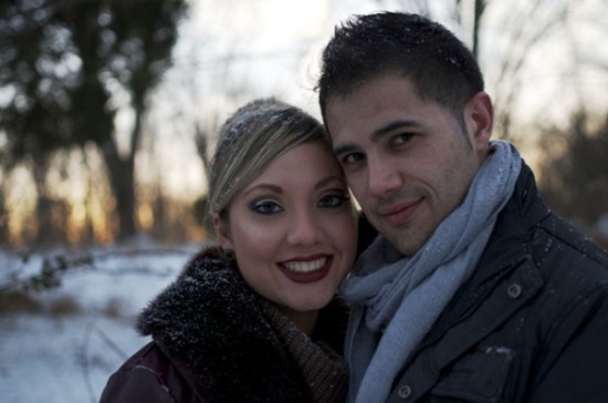Loving couple smiling for a picture in a snowy winter landscape