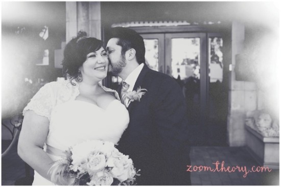 Bride smiling as groom kisses her cheek on wedding day