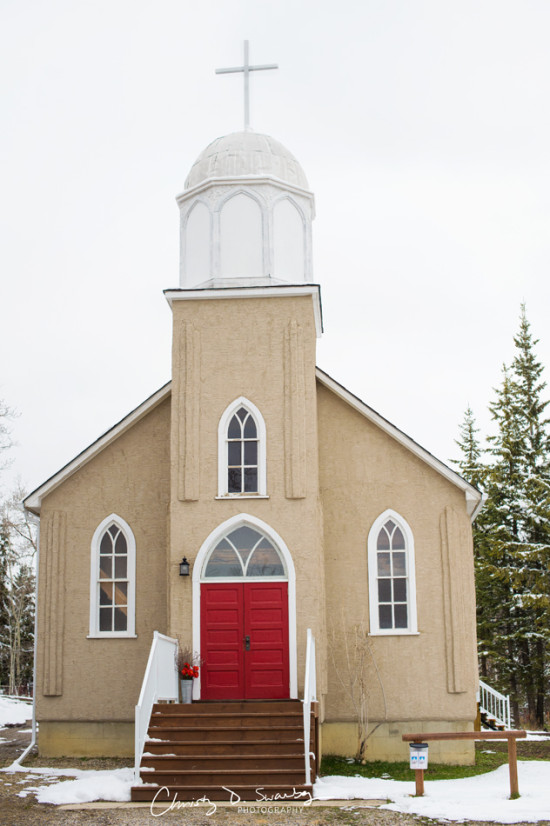 A charming church with red doors in a snowy winter landscape