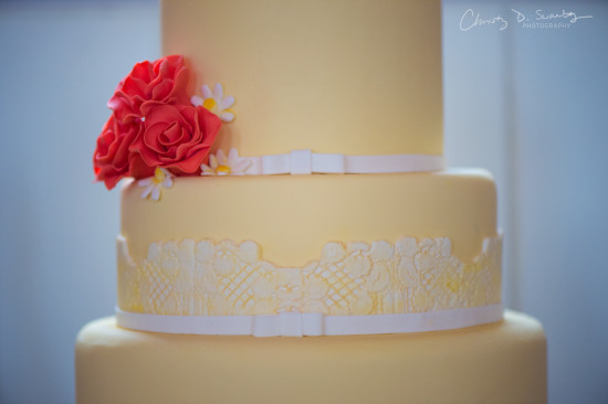 Elegant tiered wedding cake decorated with red roses and lace