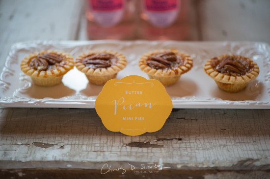 Delicious mini pecan pies on a white tray with a sign