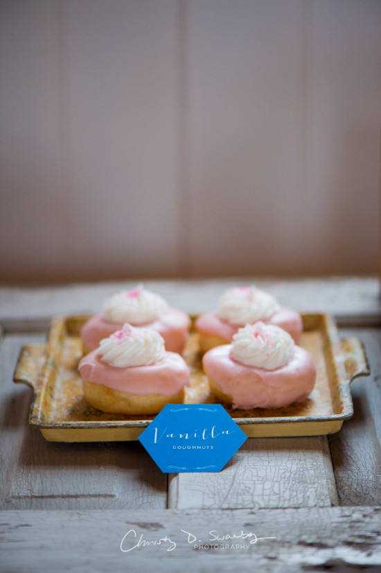 Vanilla doughnuts with pink frosting on a decorative tray