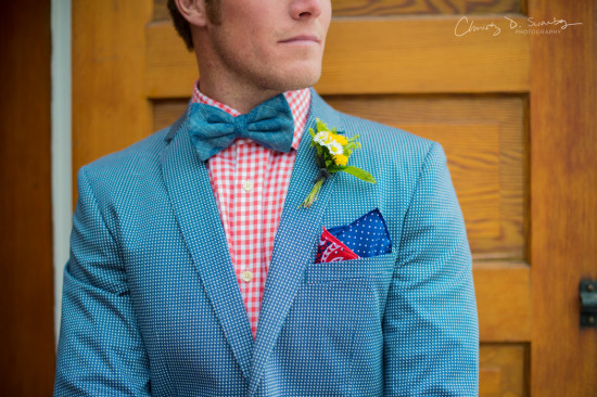 Man in a blue blazer with bow tie and flower on his suit