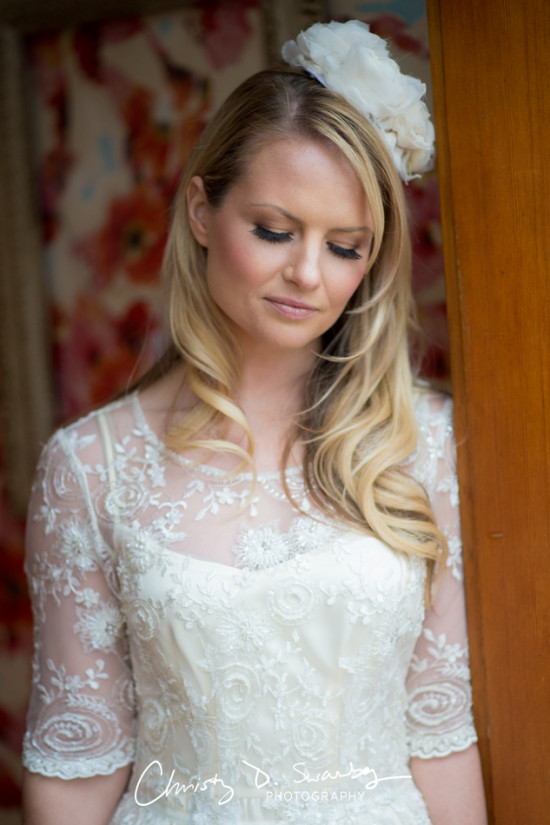 Bride in a stunning white lace dress looking down, soft focus and elegant