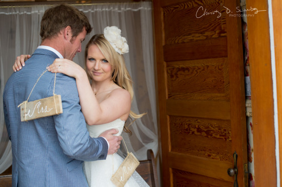 Newlywed couple embracing in a joyful moment with a Mrs sign