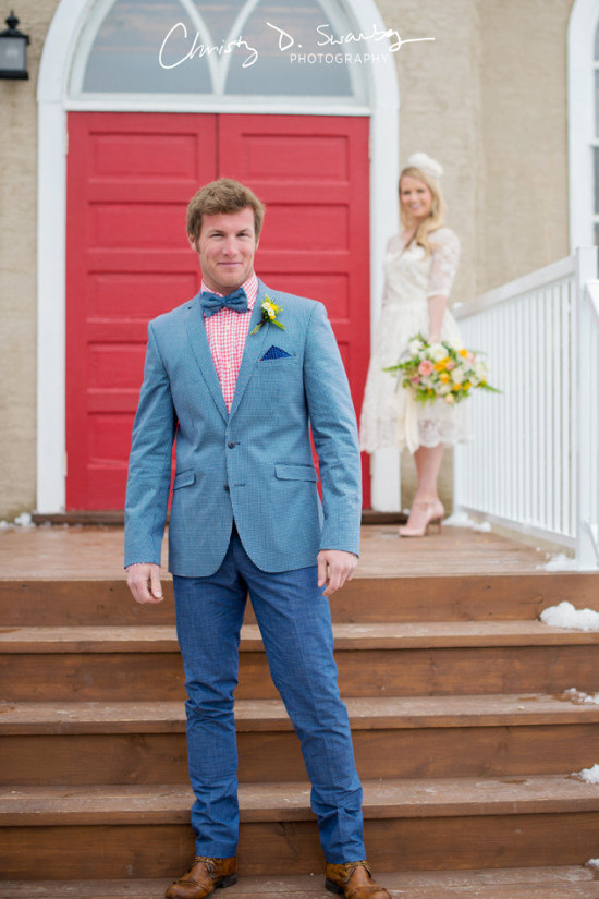 Groom smiles as bride watches on a church steps, wedding day
