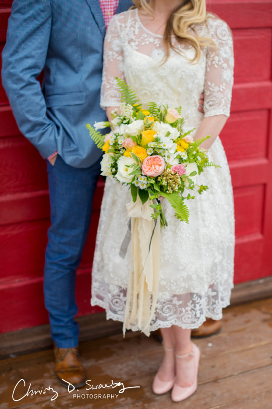 Bride in lace dress holding colorful wedding bouquet