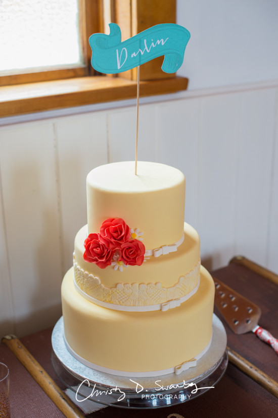 Three-tiered wedding cake with Darlin banner and red roses decoration