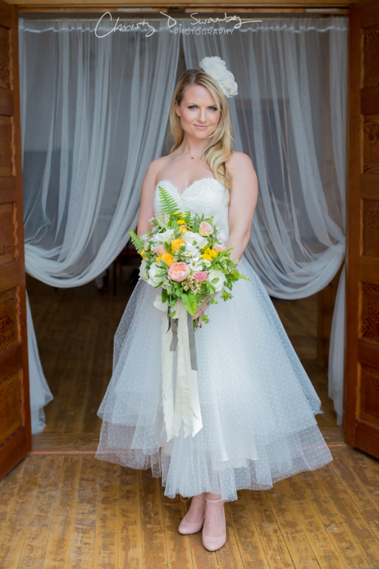 Beautiful bride in a short wedding dress holding a bouquet