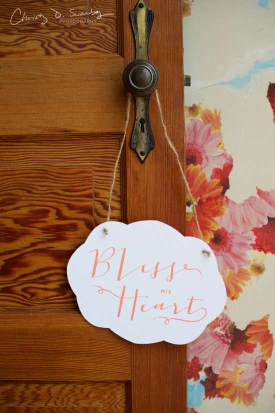 Wooden door with a cloud shaped sign saying Bless His Heart