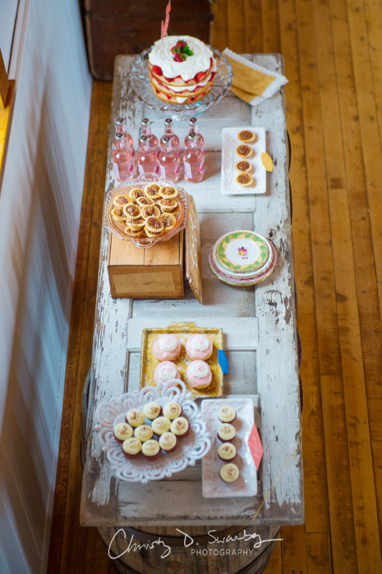 Dessert table with cake, cupcakes, and pink beverages for a party