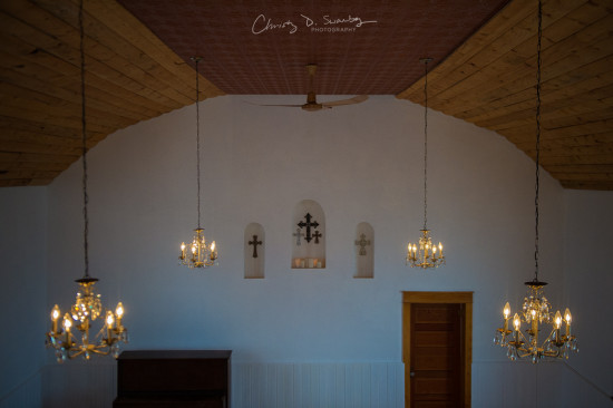 Elegant chandeliers illuminate an empty church interior with crosses
