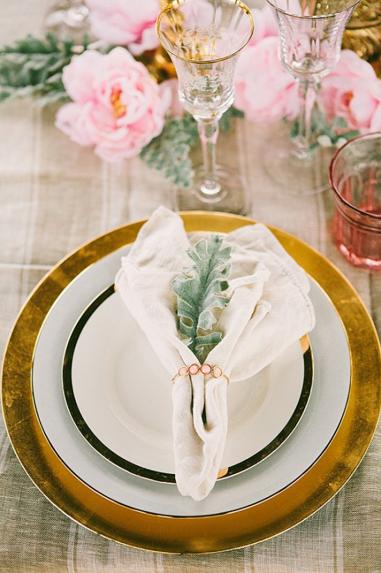 Elegant table setting with gold charger and pink flower decor