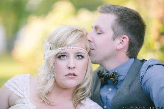 Bride and groom embrace romantically in soft focus outdoor photo