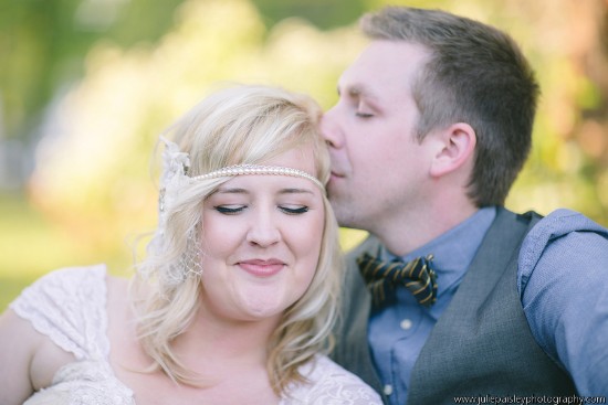 Bride receiving a kiss on her forehead from her groom