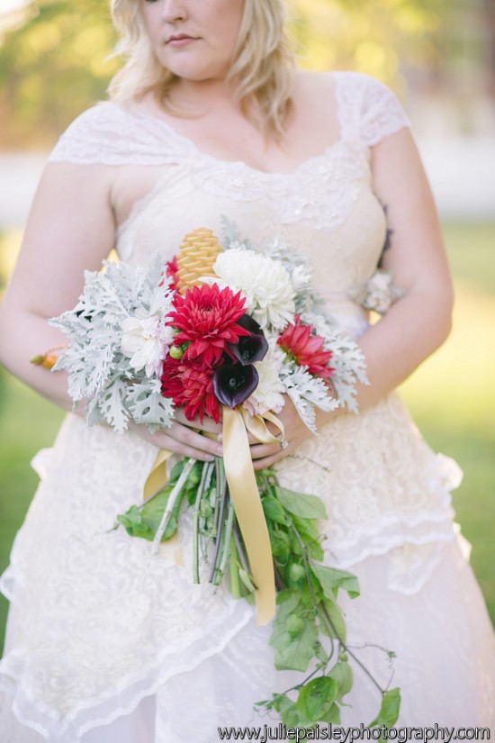 Bride holding vibrant bouquet in an elegant lace wedding dress
