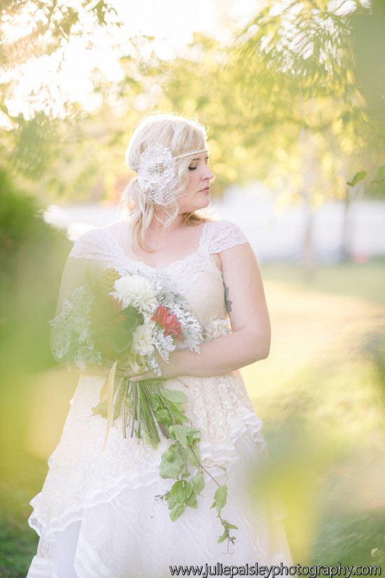 Boho bride with flower crown holding bouquet outdoors