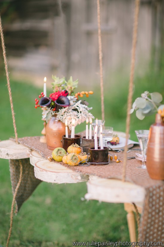 Romantic outdoor table setting with candles and autumn decor