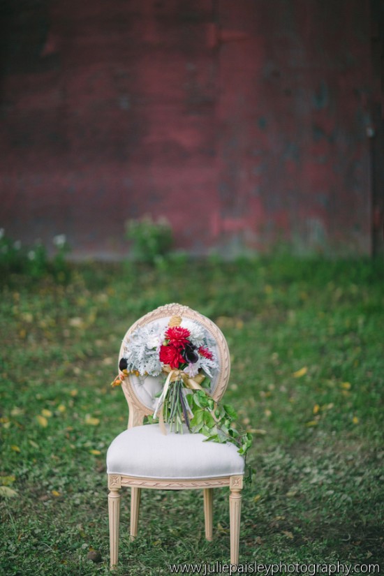 Elegant bouquet on a vintage chair in a grassy field, red flowers