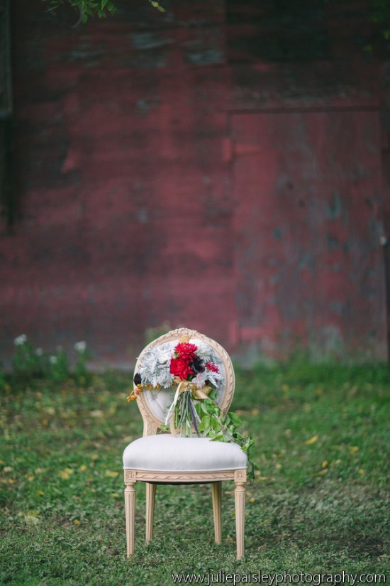 Vintage chair with floral bouquet in front of a red wall